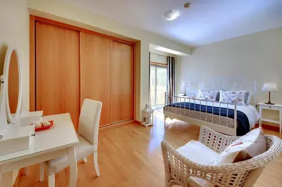 a bedroom with a bed and a desk and chairs at Marina Coast Residence in Albufeira