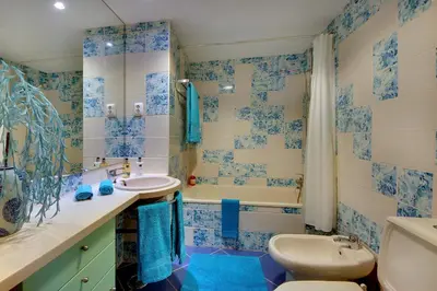a blue and white bathroom with a toilet and a tub at Marina Coast Residence in Albufeira