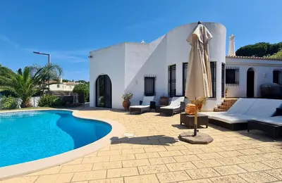 a patio with a swimming pool and an umbrella at Dunas Douradas Beach Villa in Benfarras