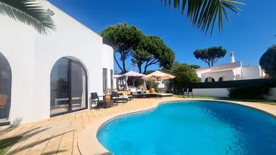 a swimming pool in front of a house at Dunas Douradas Beach Villa in Benfarras