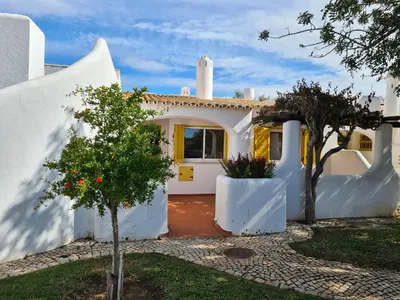 a white house with a tree in front of it at Aldeia do Golf - Vila I8 in Vilamoura