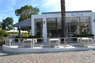 a building with tables and chairs in front of it at Quinta do lago & golf in Quinta do Lago