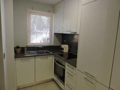 a kitchen with white cabinets and a sink and a window at Sao Rafael - Apartamento Studio in Albufeira