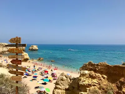 a beach with a bunch of people and the ocean at Sao Rafael - Apartamento Studio in Albufeira