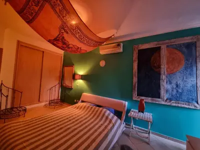 a bedroom with a bed and a green wall at T1 Falesia in Albufeira