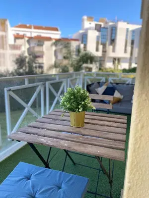 a wooden table with a potted plant on a balcony at Garden Hill Apartment in Albufeira