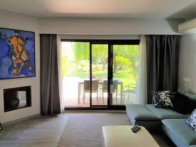 a living room with a couch and a sliding glass door at By the Beach in Almancil