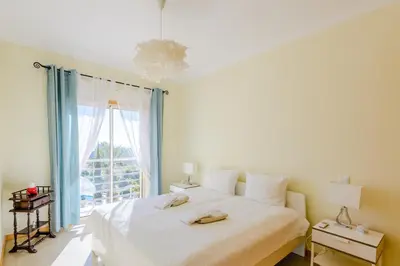 a bedroom with a large bed and a window at BnB Homes Ocean view Apartment with Lovely Terrace, 2 Swimming pools & Tennis court in Albufeira