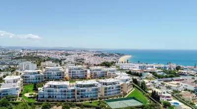 a building on the edge of the ocean at BnB Homes Ocean view Apartment with Lovely Terrace, 2 Swimming pools & Tennis court in Albufeira