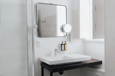 a white bathroom with a sink and a mirror at Dear Faro - Guest House in Faro