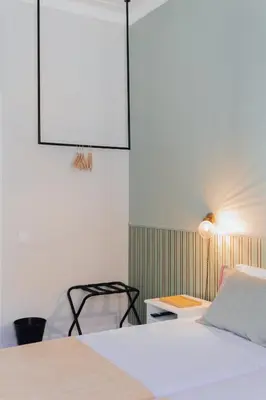 a bedroom with a white bed and a chair at Dear Faro - Guest House in Faro