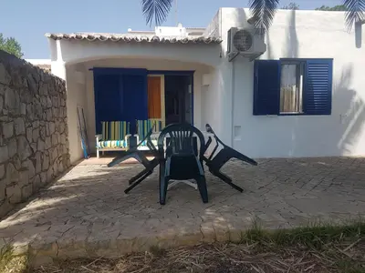 a pair of chairs sitting outside of a house at Balaia Gardens, jardins da Balaia in Albufeira