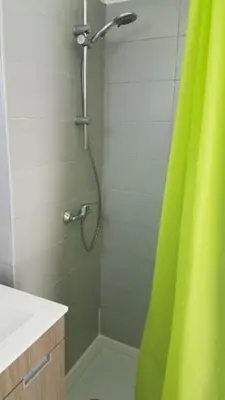 a shower with a green shower curtain in a bathroom at Balaia Gardens, jardins da Balaia in Albufeira