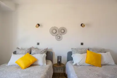 two beds with yellow pillows in a bedroom at Casa Galé - Joia das Sesmarias 600mts praia in Albufeira