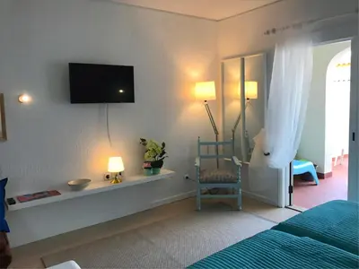 a bedroom with a bed and a tv on the wall at Albufeira Jardim 2 Studio in Albufeira