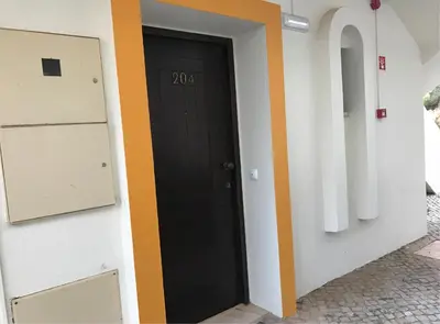 a black door with the number on it in a hallway at Albufeira Jardim 2 Studio in Albufeira
