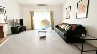 a living room with a black couch and a television at Villa Golfinho by Sunny Deluxe in Albufeira