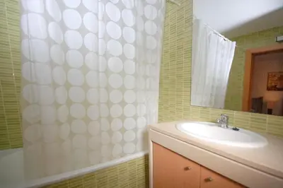a bathroom with a sink and a shower curtain at Apartamento Corcovada - By Bedzy in Albufeira