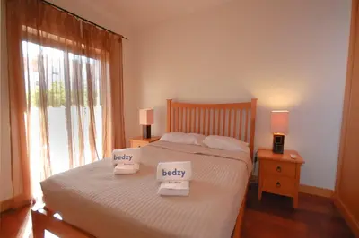 a bedroom with a bed with two towels on it at Apartamento Corcovada - By Bedzy in Albufeira