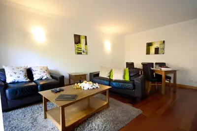 a living room with two couches and a table at Apartamento Corcovada - By Bedzy in Albufeira