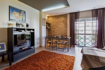 a living room with a television and a dining room at Casa das Lontras in Faro