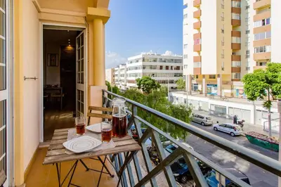 a table on a balcony with a view of a city at Casa das Lontras in Faro