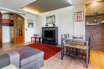 a living room with a couch and a table and a television at Casa das Lontras in Faro
