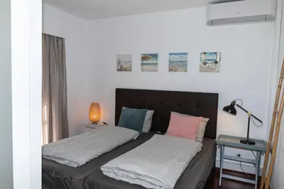 a bedroom with two beds and a table with a lamp at Olhos Do Mar Albufeira in Albufeira