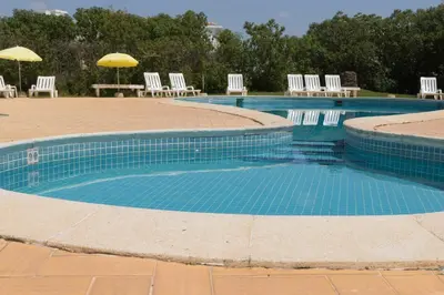 a large swimming pool with chairs and umbrellas at Olhos Do Mar Albufeira in Albufeira