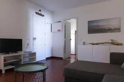 a living room with a couch and a tv at Olhos Do Mar Albufeira in Albufeira