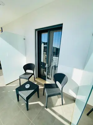 two chairs and a table in a room with windows at Sunfield Guest House - Only Adults in Albufeira