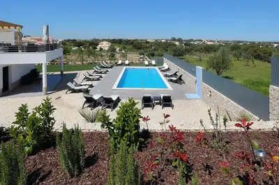 a swimming pool with chaise lounges and lounge chairs at Sunfield Guest House - Only Adults in Albufeira