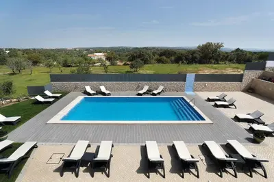 a pool with chaise lounge chairs and a swimming pool at Sunfield Guest House - Only Adults in Albufeira