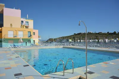 a swimming pool in front of a building at Funtastic Albufeira Marina 1b3b in Albufeira
