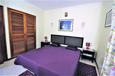 a bedroom with a purple bed in a room at Belavista Centre - Albufeira in Albufeira