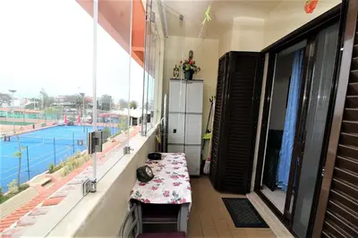 a balcony with a table and a view of a tennis court at Belavista Centre - Albufeira in Albufeira