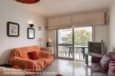 a living room with a couch and a television at Akisol Vilamoura Pine in Quarteira