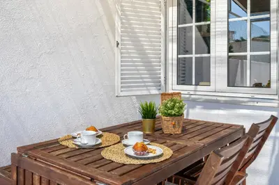 a wooden table with two plates of food on it at Charming Blue Albufeira in Albufeira