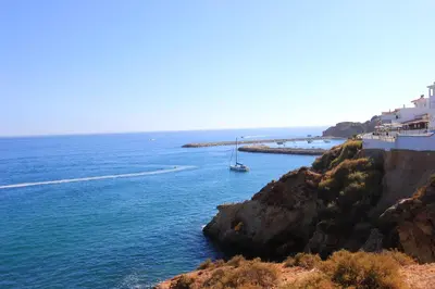 a view of the ocean with a boat in the water at Charming Blue Albufeira in Albufeira