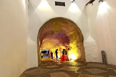 a group of people walking through a tunnel at Warm Yellow Albufeira in Albufeira
