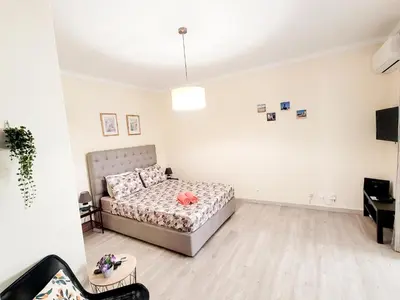 a white bedroom with a bed and a table at Reis Turismo in Faro