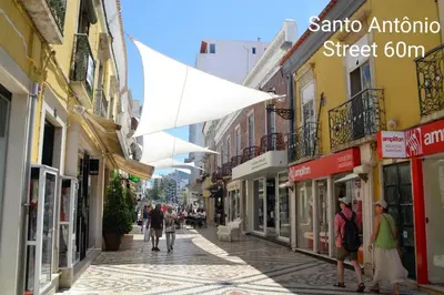 a street with people walking down a street with buildings at Reis Turismo in Faro