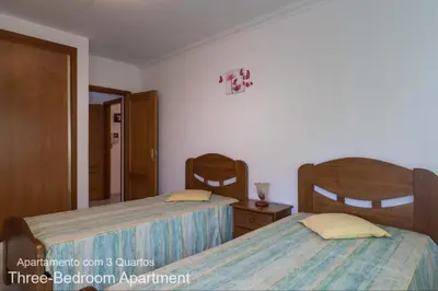 a bedroom with two beds and a mirror at Akisol Albufeira Falesia IV in Albufeira