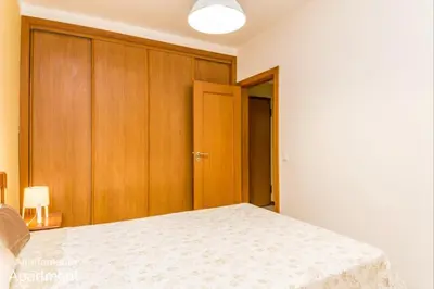 a bedroom with a bed and wooden cabinets at Akisol Albufeira Falesia IV in Albufeira