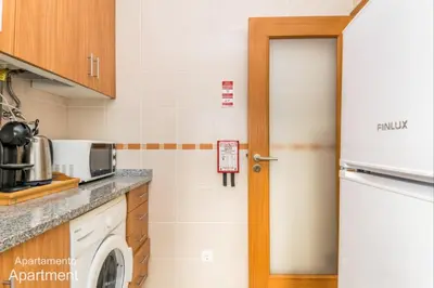 a kitchen with a washing machine and a door at Akisol Albufeira Falesia IV in Albufeira