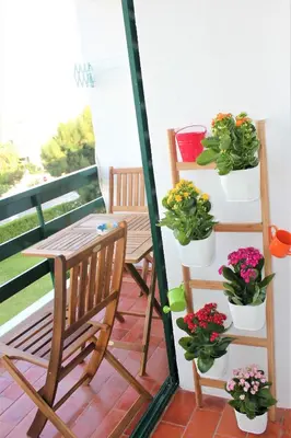 a balcony with a table and potted plants on it at Vilamoura Dolphin Studio in Vilamoura