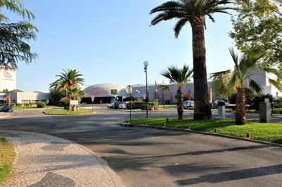 a street with palm trees and a parking lot at Vilamoura Dolphin Studio in Vilamoura