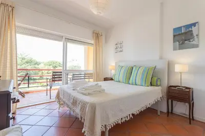 a bedroom with a bed and a balcony at FLH Vilamoura Central Flat in Quarteira