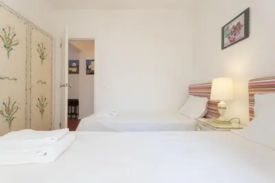two white beds in a bedroom with a doorway at FLH Vilamoura Central Flat in Quarteira