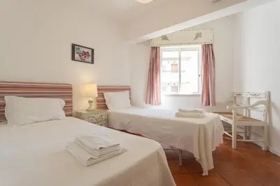 a bedroom with two beds and a window at FLH Vilamoura Central Flat in Quarteira